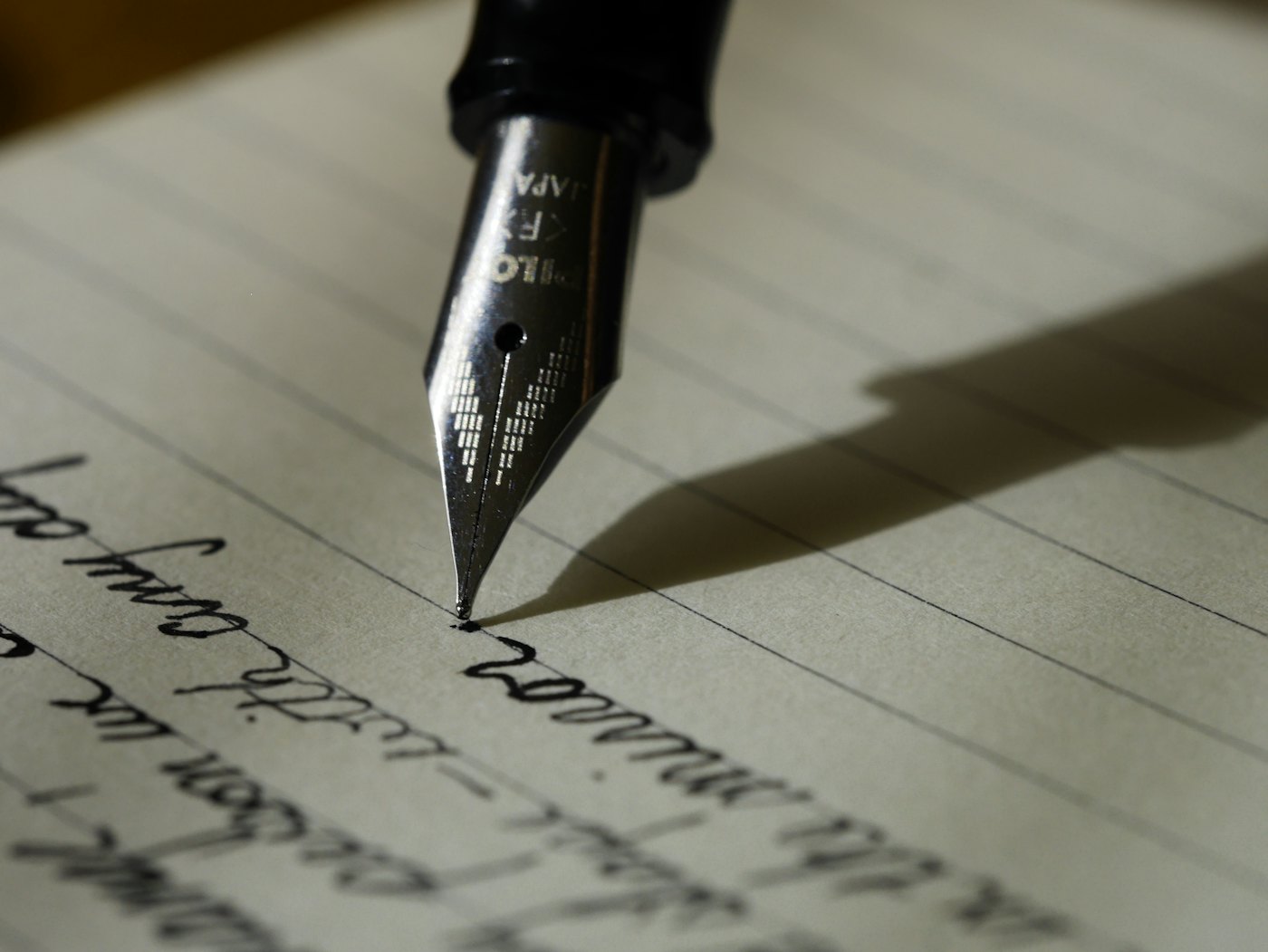 Una pluma escribe en un cuaderno
