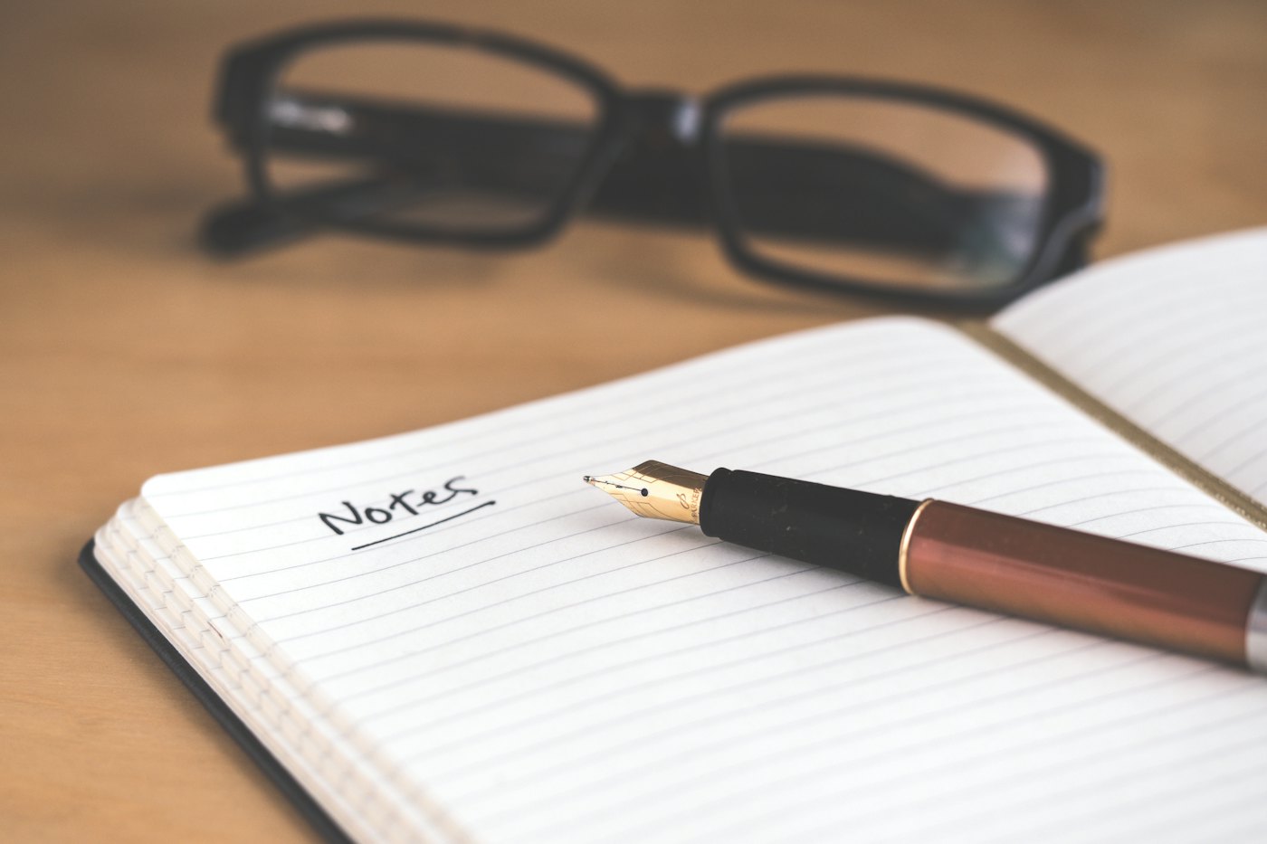 Anteojos y una lapicera sobre un cuaderno
