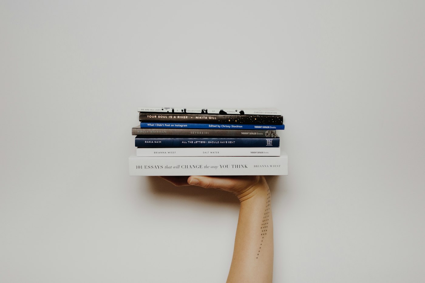 Una mano sostiene una pila de libros